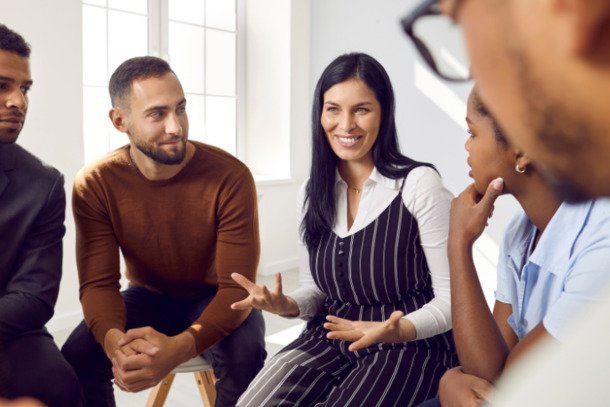 Image shows a group of people sitting and smiling