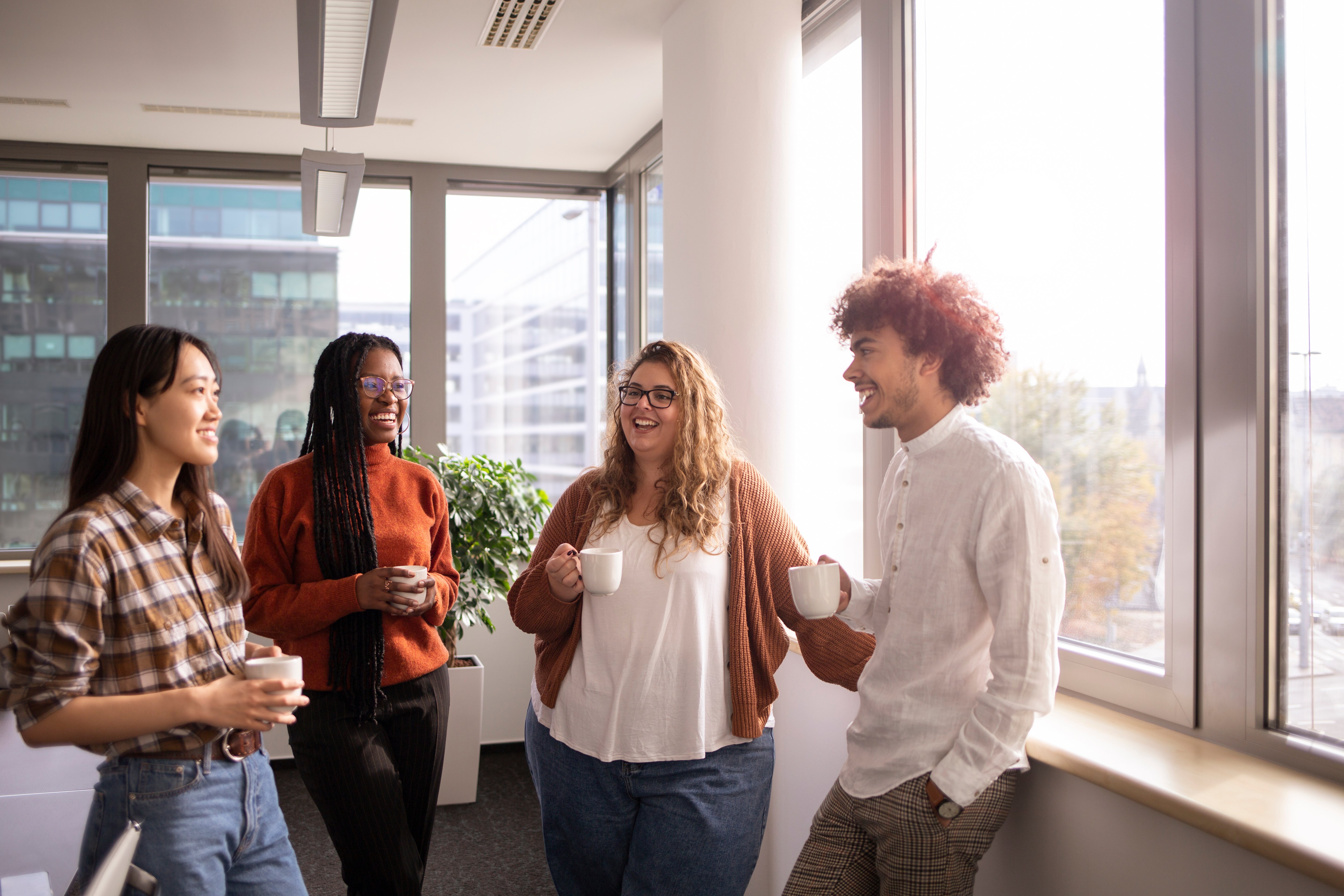 Group of people talking in office over coffee