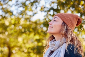 Young woman practising breathing exercise in the forest.