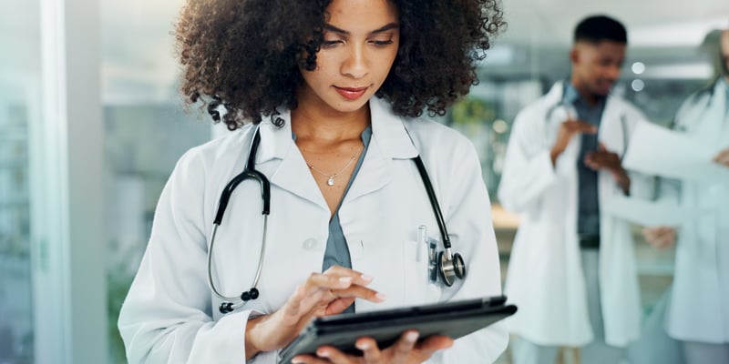 a female doctor looking at some information on an iPad