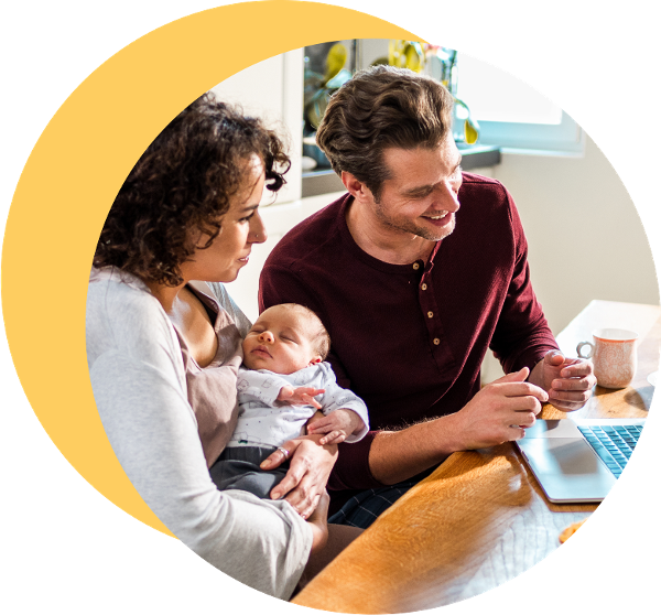 Man and woman with a new born baby speaking to someone on laptop