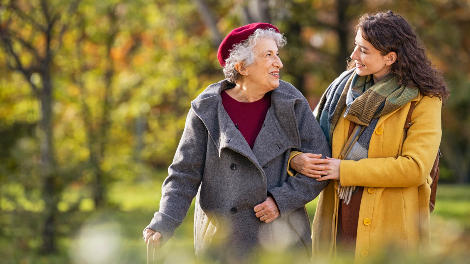 A woman walking with an elderly woman in nature