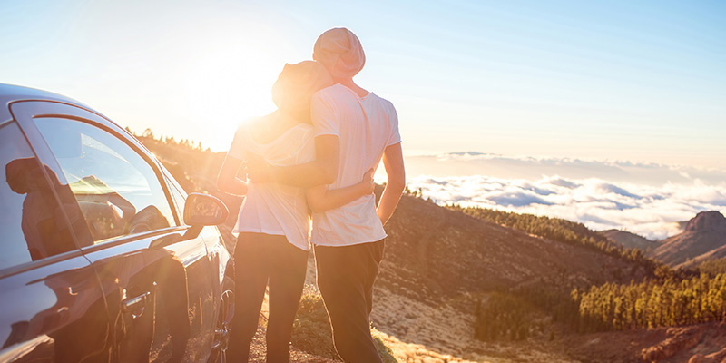 Two people hugging on hill looking over the horizon