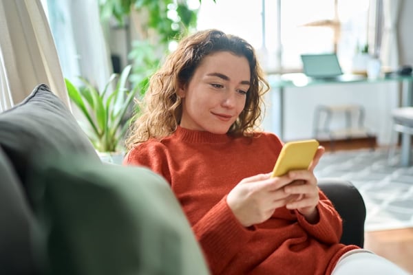 A woman in her living room looking at her phone