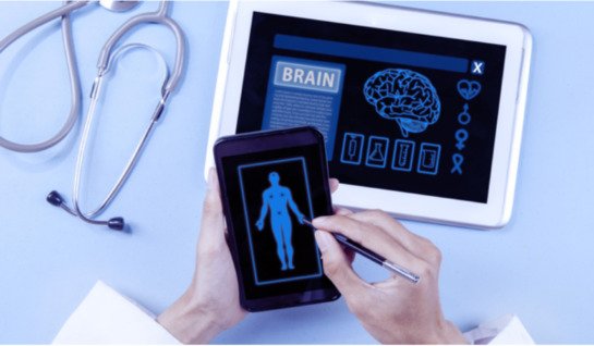 Image shows a phone in someone's hands with an illustration of a body on screen and a tablet on the surface below with an illustration of the human brain and a stethoscope lying beside it