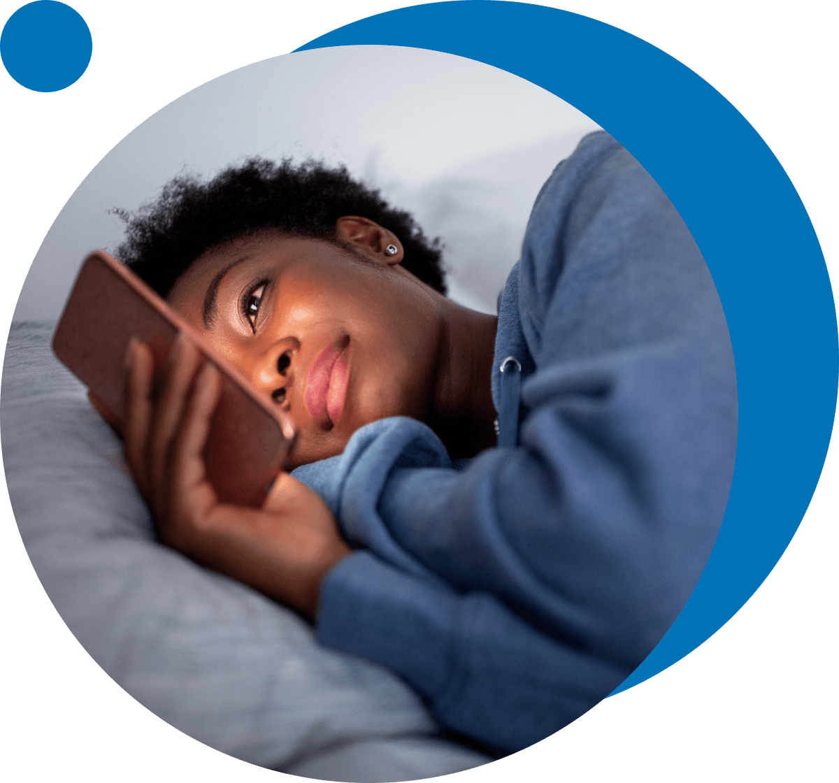 young woman looking at phone while in bed